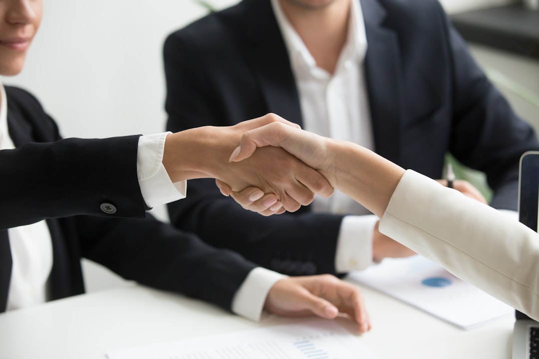 the-story two-people-shaking-hands-in-front-of-a-laptop-xeq8xewb4q